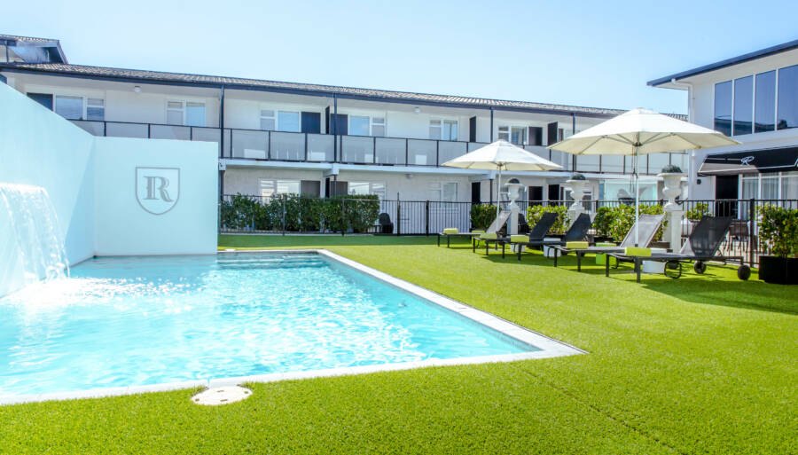 The Regent Rotorua hotel surrounding its outdoor swimming pool and courtyard