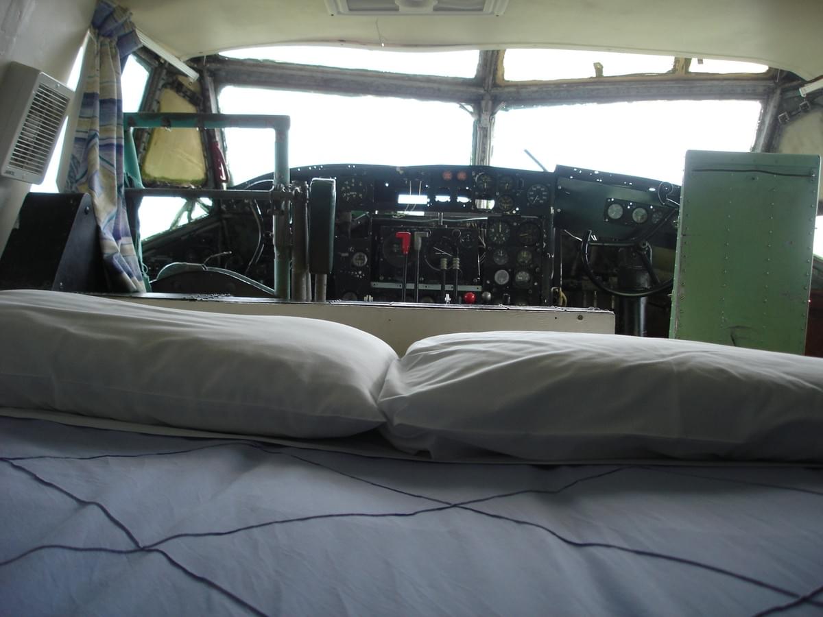 A bed in the cockpit of the Bristol Freighter plane at Woodlyn Park, facing the original instrument panel